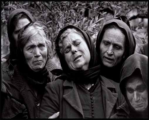 grupo de mujeres de negro, lamentándose dramáticamente en un cortejo fúnebre