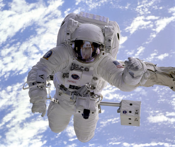The pale blue Earth serves as a backdrop for astronaut Michael Gernhardt, who is attached to the Shuttle Endeavour’s robot arm during a spacewalk on the STS-69 mission in 1995. Unlike earlier spacewalking astronauts, Gernhardt was able to use an electronic cuff checklist, a prototype developed for the assembly of the International Space Station.