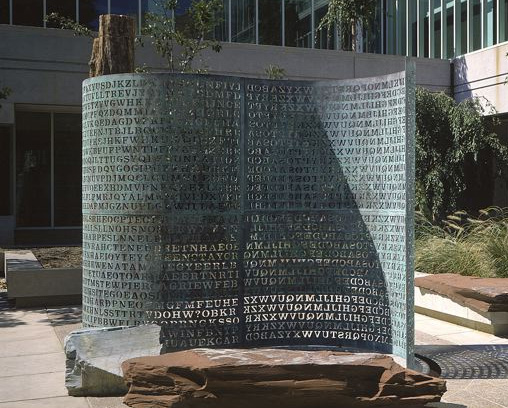 "Kryptos", de James Sanborn, es una de las tres esculturas que se encuentran en los terrenos del Centro de Inteligencia George Bush. Ejecuta un tema de recopilación de información e incluye una pantalla de cobre codificada. Imagen de baja resolución de la escultura Kryptos de la CIA, proporcionada por el escultor, w:Jim Sanborn.
