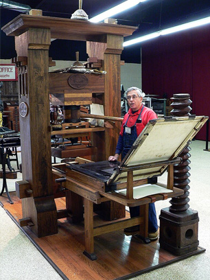 Peter Small demonstrating the use of the Gutenberg press at the International Printing Museum.
