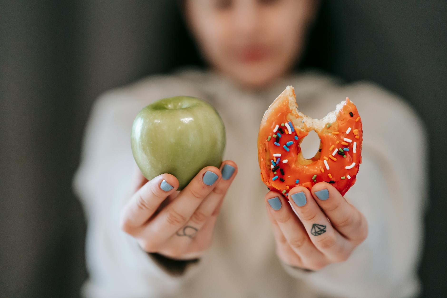 mujer mostrando manzana y rosquilla mordida
