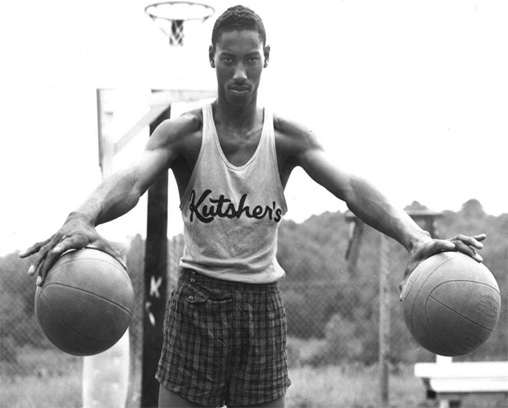 Wilt Chamberlain sosteniendo una pelota de baloncesto