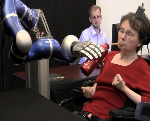 Persona con una interfaz cerebro-computadora que controla un brazo robótico.  
