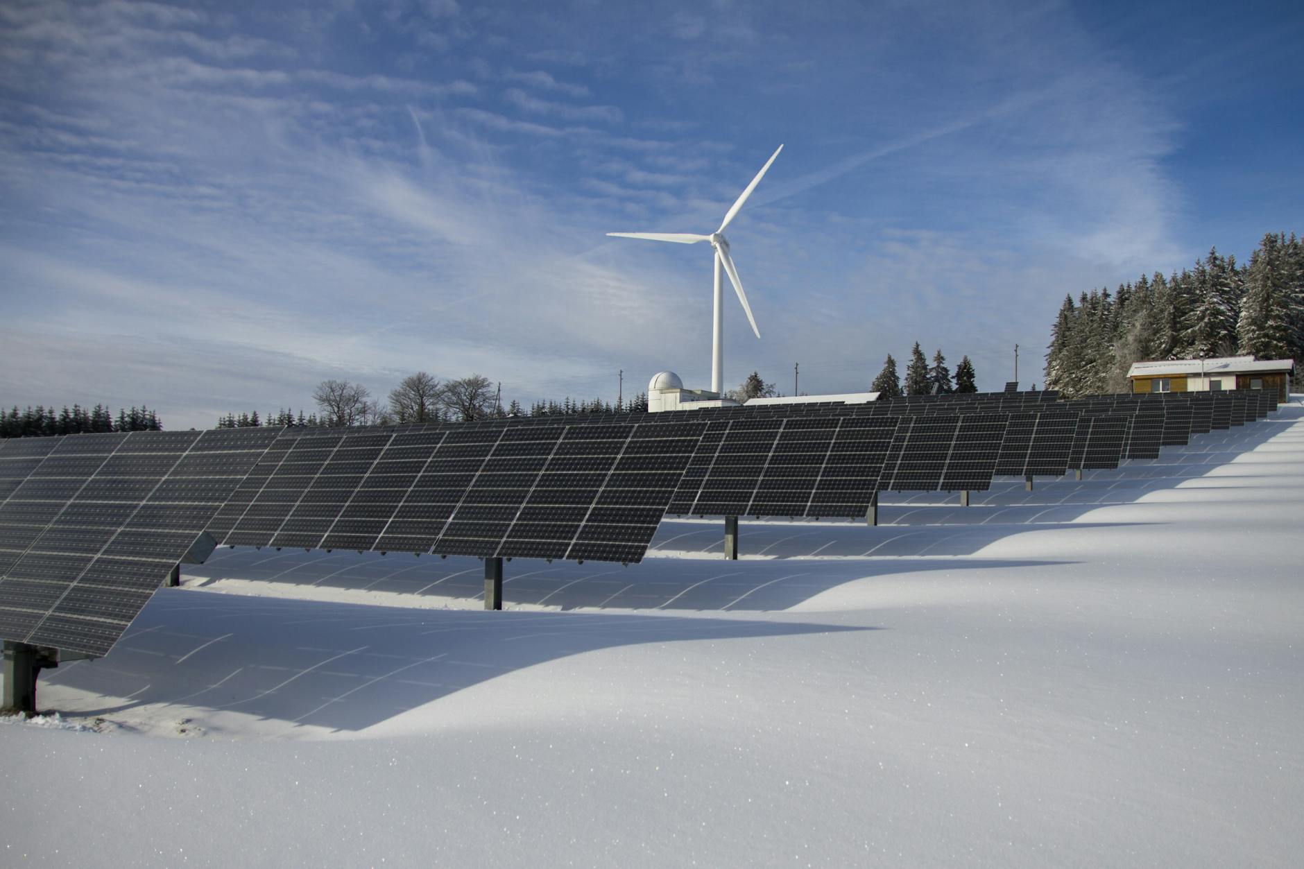 panneaux solaires sur la neige avec moulin à vent sous ciel clair