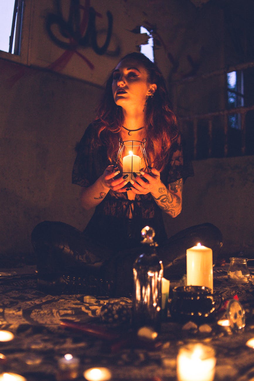 Bruja espeluznante entre velas durante el ritual