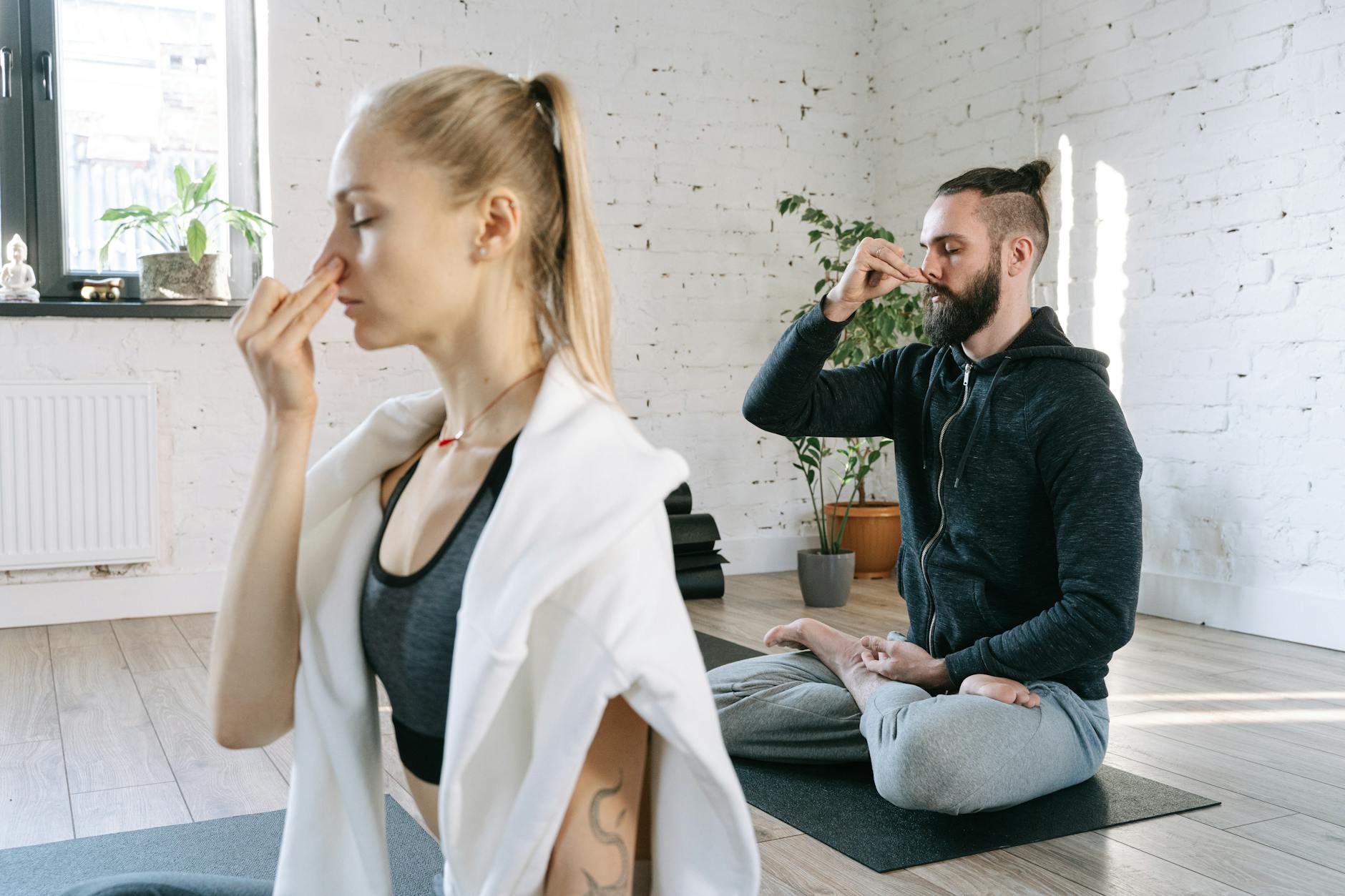 un hombre y una mujer haciendo yoga