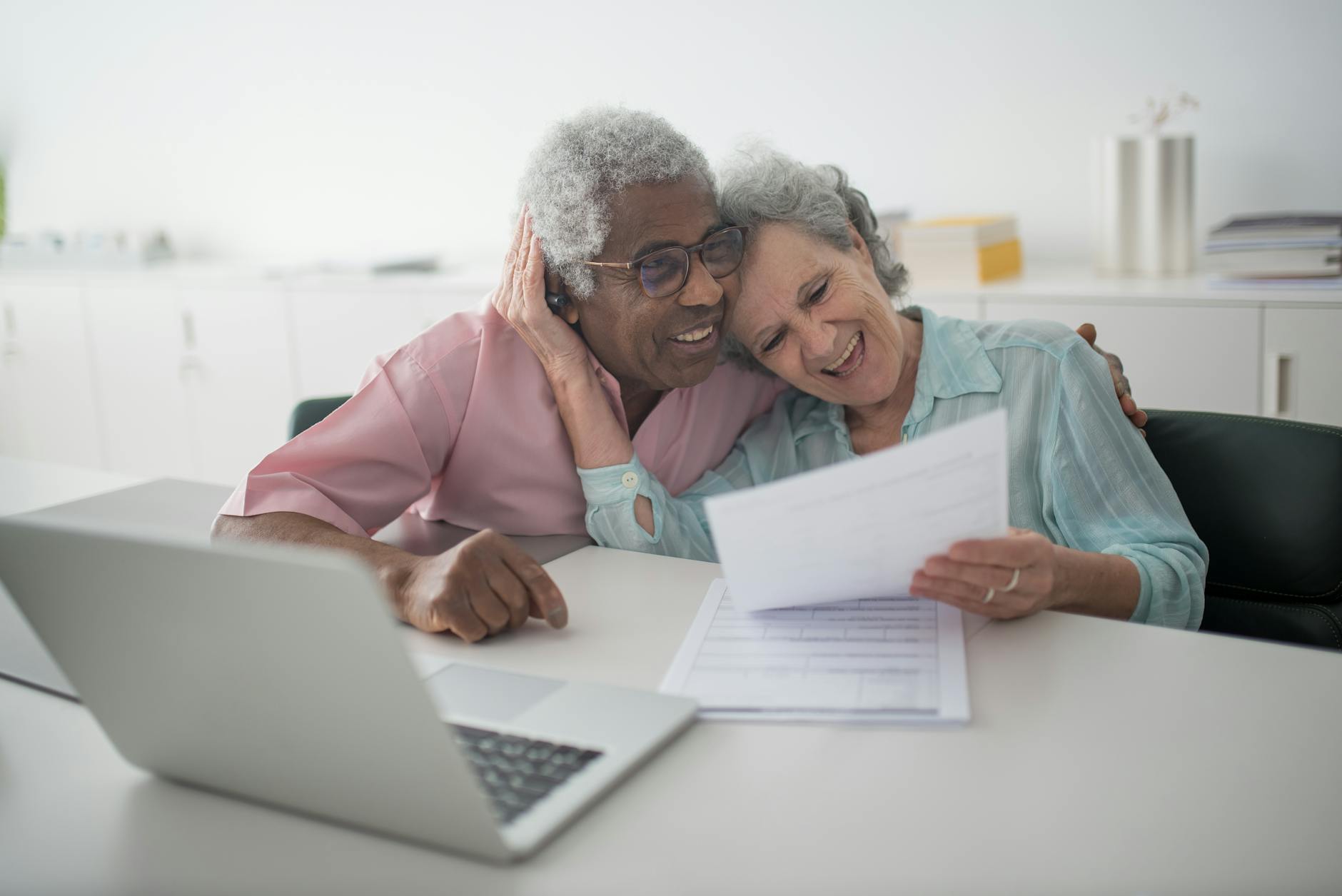 un couple de personnes âgées heureux tenant un document