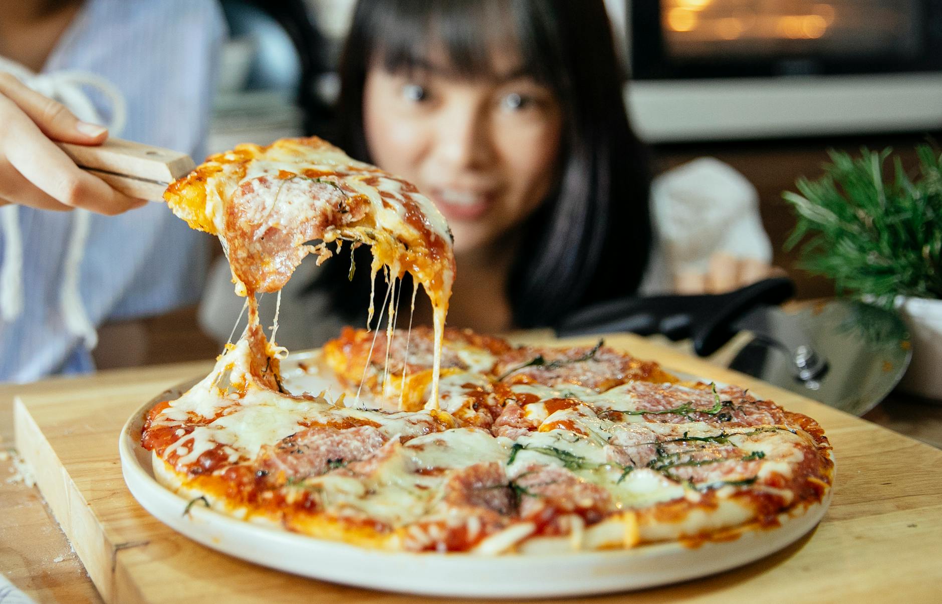 Des femmes prennent un morceau de pizza avec des tomates et du fromage