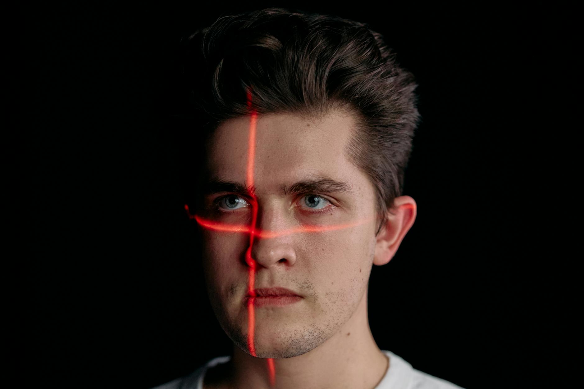 portrait photo of man with laser lines on his face