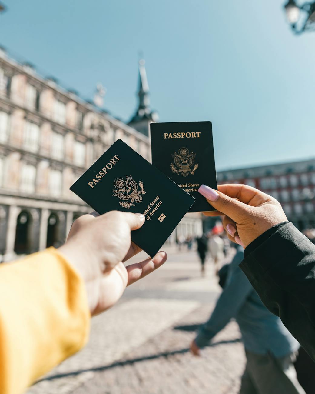 Turistas anónimos mostrándonos pasaportes en la calle en un día soleado