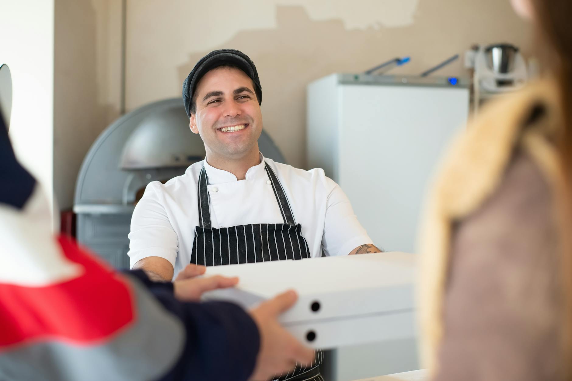 Happy Baker offrant des boîtes de pizza aux clients